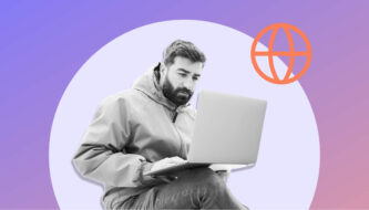 Mann mit Laptop auf dem Schoß vor lila Hintergrund.